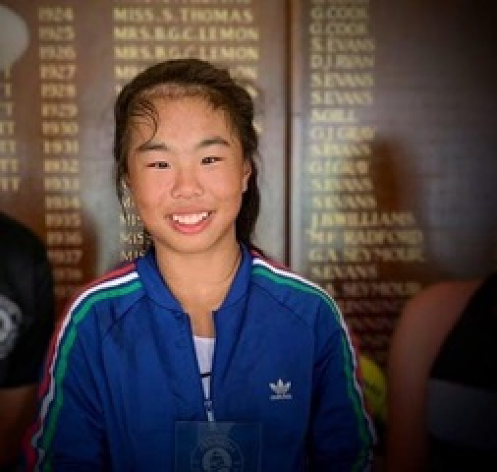 Mimi Xu in front of the champions board at Penarth Lawn Tennis Cub aged 11 in 2019